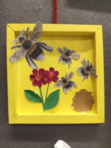 IMG_20250617_160431425 Artwork created by service users of the women's centre shows bees and flowers in a yellow frame